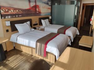 two beds in a hotel room with two bedsskirts at Thank Inn Chain Hotel Guizhou Qiannan Duyun Beibu Xingcheng 