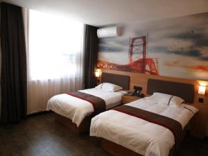 two beds in a hotel room with a painting on the wall at Thank Inn Chain Hotel Shandong Linyi Lanshan District Liguan Town in Linyi