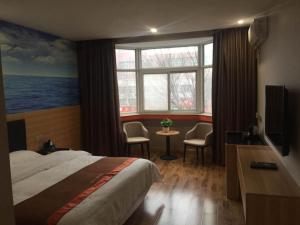 a hotel room with a bed and a table with chairs at JUN Hotels Henan Luoyang Xigong District Central Bus Station in Luoyang