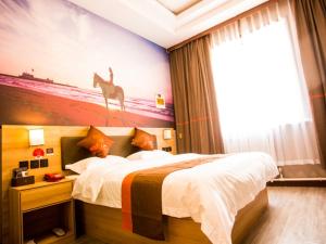 1 dormitorio con 1 cama y una pintura de una jirafa en JUN Hotels Shandong Heze Mudan District Sanjiao Garen, en Heze