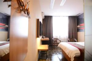 a hotel room with two beds and a desk at Thank Inn Chain Hotel Hebei Handan Wu'an City Bus Station in Handan