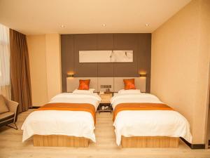 a room with three beds in a hotel room at JUN Hotels Hebei Shijiazhuang Wuji County Zhengyi Street Store in Shijiazhuang