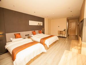 2 camas en una habitación de hotel con en JUN Hotels Hebei Shijiazhuang Wuji County Zhengyi Street Store, en Shijiazhuang