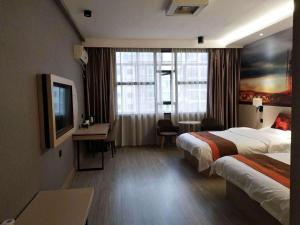 um quarto de hotel com duas camas e uma secretária em JUN Hotels Liuzhou Sanjiang County Dongxiang Avenue em Sanjiang