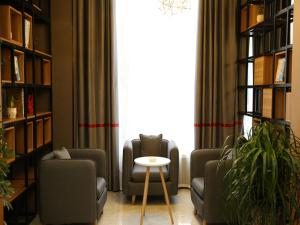 a living room with two chairs and a table at Thank Inn Chain Hotel Xinyang Gushi County Hongsu Avenue 