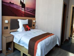 a bedroom with a large bed with a dog on it at JUN Hotels Shandong Binzhou Yangxin County Yangcheng 3rd Road in Binzhou