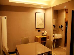 a room with a table and a bathroom with a sink at Up And In Jiangsu Yancheng Tinghu District Yancheng Bridge Store in Yancheng
