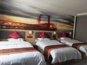 3 camas en una habitación con una pintura en la pared en JUN Hotels Dezhou Decheng District Hubin South Avenue Wanda Plaza, en Dezhou