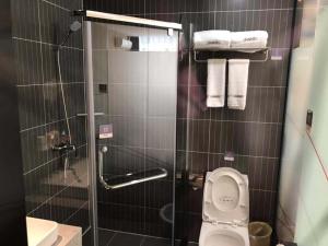ein Badezimmer mit Toilette und Dusche mit Handtüchern in der Unterkunft Thank Inn Chain Hotel Guangdong Dongguan Daling Mountain Guanchang Road in Dongguan
