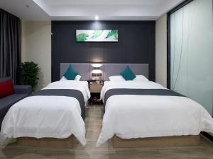 1 dormitorio con 3 camas y TV en la pared en Up And In Hubei Xianning Tongshan County Building Material Market, en Xianning
