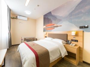 a bedroom with a large bed and a painting on the wall at Thank Inn Chain Hotel Shanghai Songjiang District Yongfeng Road Store in Shanghai