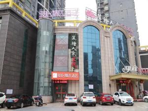 a building with cars parked in front of it at JUN Hotels Jiangnan Nanchang Nanchang County Xiaolan Industrial Park in Nanchang