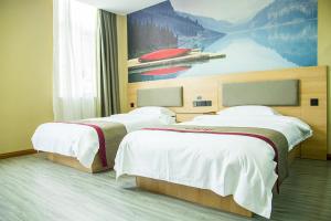 2 camas en una habitación de hotel con un cuadro en la pared en Thank Inn Chain Hotel Hebei Handan Wu'an City Bus Station, en Handan