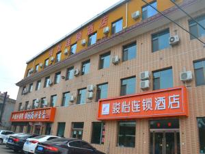 een groot bakstenen gebouw met auto's geparkeerd voor het bij JUN Hotels Shanxi Lvliang Lishi District Lvliang Academy West Gate in Luliang