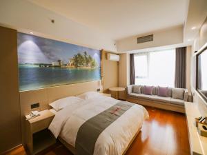 a bedroom with a large bed and a large painting on the wall at JUN Hotels Liaoning Anshan Railway Station Wanxianghui in Anshan