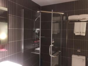 eine Dusche im Bad mit schwarzen Fliesen in der Unterkunft Thank Inn Chain Hotel Guangdong Dongguan Daling Mountain Guanchang Road in Dongguan + 6 Fotos