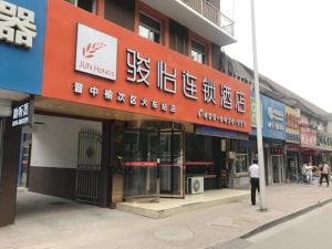 a man standing in front of a building at JUN Hotels Jinzhong Yuci District Railway Station in Jinzhong