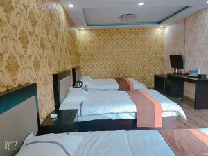 a hotel room with two beds and a television at JUN Hotels Hebei Zhangjiakou Xuanhua District Railway Station Store in Zhangjiakou