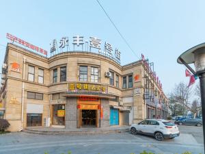 ein Gebäude mit einem davor geparkt in der Unterkunft Thank Inn Chain Hotel Shanghai Songjiang District Yongfeng Road Store in Shanghai