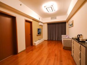 a living room with a hard wood floor and a hallway at JUN Hotels Liaoning Anshan Railway Station Wanxianghui in Anshan