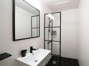 La salle de bains est pourvue d'un lavabo et d'une douche. dans l'établissement Wegoinn Hostel, à Séoul