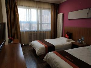 JUN Hotels Gansu Lanzhou Chengguan DIstrict Lanzhou University tesisinde bir odada yatak veya yataklar