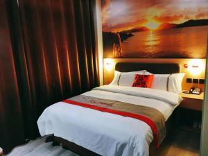 een slaapkamer met een groot bed en een schilderij aan de muur bij JUN Hotels Shandong Taian Dongping Museum in Dongping