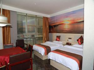 a hotel room with two beds and a painting on the wall at JUN Hotels Jiangnan Nanchang Nanchang County Xiaolan Industrial Park in Nanchang