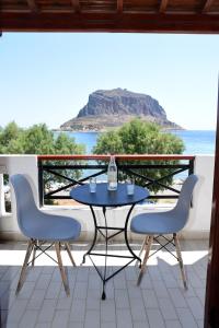 una mesa y sillas en un balcón con vistas al océano en AGNANTIO en Monemvasia