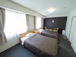 Un ou plusieurs lits dans un hébergement de l'établissement Hotel Shin Osaka