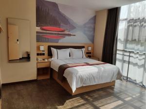 una camera con un grande letto e una grande finestra di Thank Inn Chain Hotel Guizhou Qiannan Duyun Beibu Xingcheng 