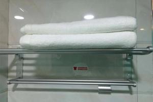 three towels on a towel rack in a bathroom at JUN Hotels Guangdong Shenzhen Yantian District Zhongying Street in Shenzhen