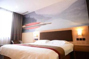 a bedroom with a large bed with a painting on the wall at Thank Inn Chain Hotel Hebei Handan Wu'an City Bus Station in Handan