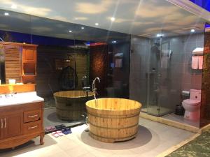 a large bathroom with two tubs and a shower at JUN Hotels Jiangnan Nanchang Nanchang County Xiaolan Industrial Park in Nanchang