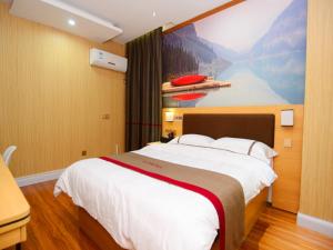 a bedroom with a large bed with a painting on the wall at Thank Inn Chain Hotel Jiangxi Fuzhou Dongxiang District High Speed ââRailway Station in Fuzhou +10 photos