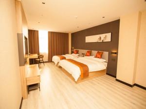 Großes Hotelzimmer mit 2 Betten und einem Schreibtisch in der Unterkunft JUN Hotels Hebei Shijiazhuang Wuji County Zhengyi Street Store in Shijiazhuang
