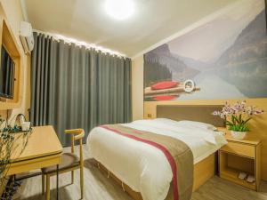 a hotel room with a large bed and a desk at Thank Inn Chain Hotel Yunnan Lijiang Old Town Dashuiche North Gate in Lijiang
