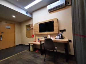 a room with a desk and a television on a wall at Thank Inn Chain Hotel Anhui Fuyang Funan County Yunhe East Road Store in Fuyang