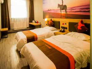 una habitación de hotel con 2 camas y una pintura de un camello en JUN Hotels Shandong Heze Mudan District Sanjiao Garen, en Heze