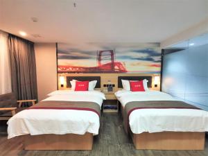 duas camas num quarto de hotel com um quadro na parede em Thank Inn Chain Hotel Guangan Huaying Phoenix City em Shuang-ho