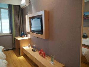 a hotel room with a television on the wall at JUN Hotels Hebei Hengshui Shenzhou Bus Station in Hengshui