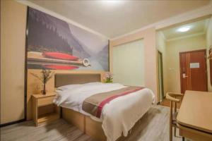 a bedroom with a large bed and a painting on the wall at Thank Inn Chain Hotel Yunnan Lijiang Old Town Dashuiche North Gate in Lijiang