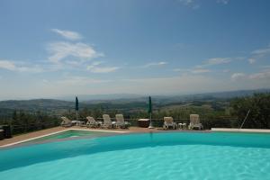 a large swimming pool with chairs and a view at Hotel Il Castellaccio in Piccione