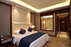 a bedroom with a large bed and a large mirror at Taizhou Haiyan Jinling International Hotel in Taizhou