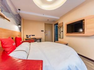 a bedroom with a large white bed and a flat screen tv at Thank Inn Chain Hotel Luoyang Jianxi District Jianshe Road in Luoyang