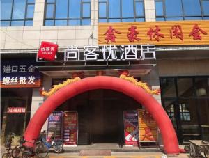 ein Restaurant mit einem roten Bogen vor einem Gebäude in der Unterkunft Thank Inn Chain Hotel Guangdong Dongguan Daling Mountain Guanchang Road in Dongguan