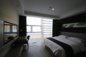 a bedroom with a large bed and a large window at Up And In Anhui Huainan Tianjiaan District Hualian Commercial Building in Huainan
