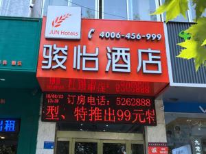 a sign for a store with chinese writing on it at JUN Hotels Shandong Heze Mudan District Sanjiao Garen in Heze