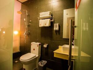 a bathroom with a toilet and a sink at JUN Hotels Shandong Heze Mudan District Sanjiao Garen in Heze