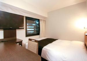 A bed or beds in a room at APA Hotel Akihabara-Ekimae